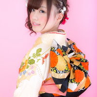 着物美女の振り返り、ピンク背景で笑顔、成人式の振袖姿の写真