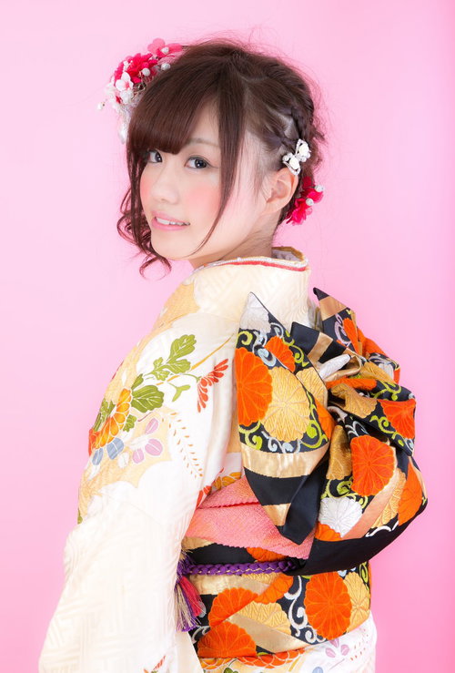 着物美女の振り返り、ピンク背景で笑顔、成人式の振袖姿の写真