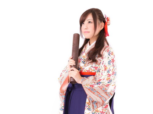 卒業証書を持った振袖姿の女性、赤い髪飾りで華やかに装う