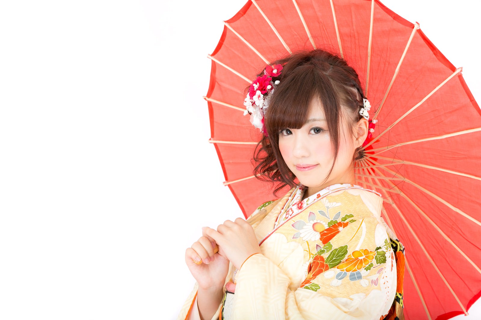 赤い和傘を持つ花飾りの髪飾りをした着物姿の女性［モデル：河村友歌］