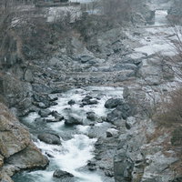 ゴツゴツした岩と流れる冬の鬼怒川、日光の渓谷風景の写真
