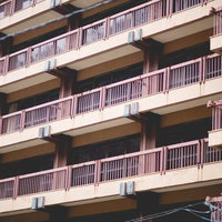 廃館のベランダ 古い建物の劣化した外観 連続する手すりの写真