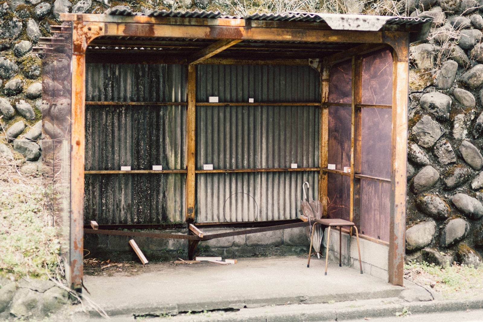 石垣沿いに建つトタン屋根の古いバス停