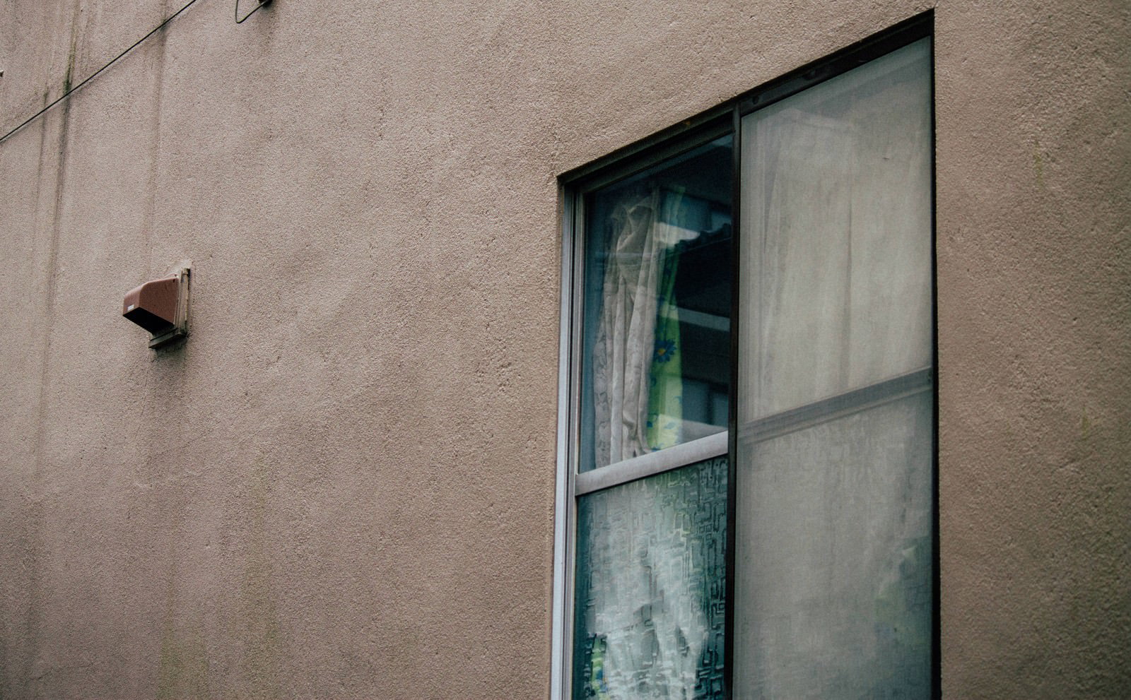 古い建物のくすんだ外壁と黒枠の窓