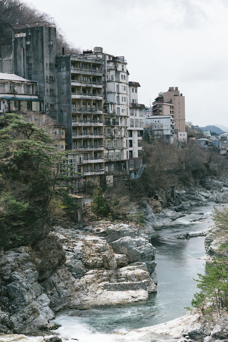川沿いに並ぶ廃墟となった鬼怒川温泉の旧旅館群
