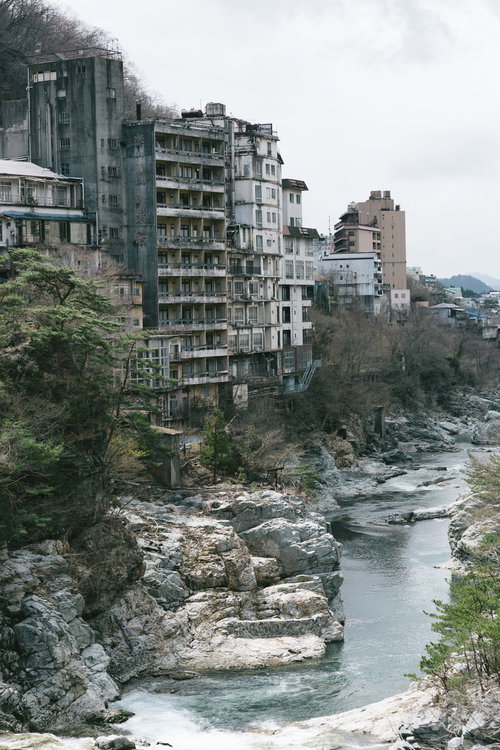 廃虚と化した鬼怒川温泉の旧旅館群と河川風景