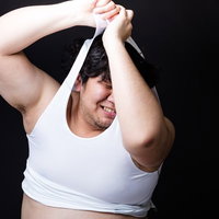 タイトな女性用スポーツウェアに無理やりねじ込もうとする戦うバディの男性の写真