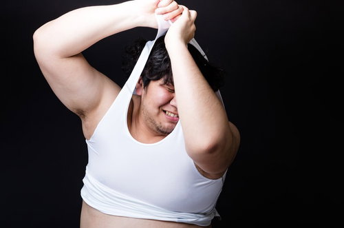 タイトな女性用スポーツウェアに無理やりねじ込もうとする戦うバディの男性の写真