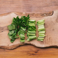 木製まな板で小松菜をざく切り - 調理工程の食材準備の写真