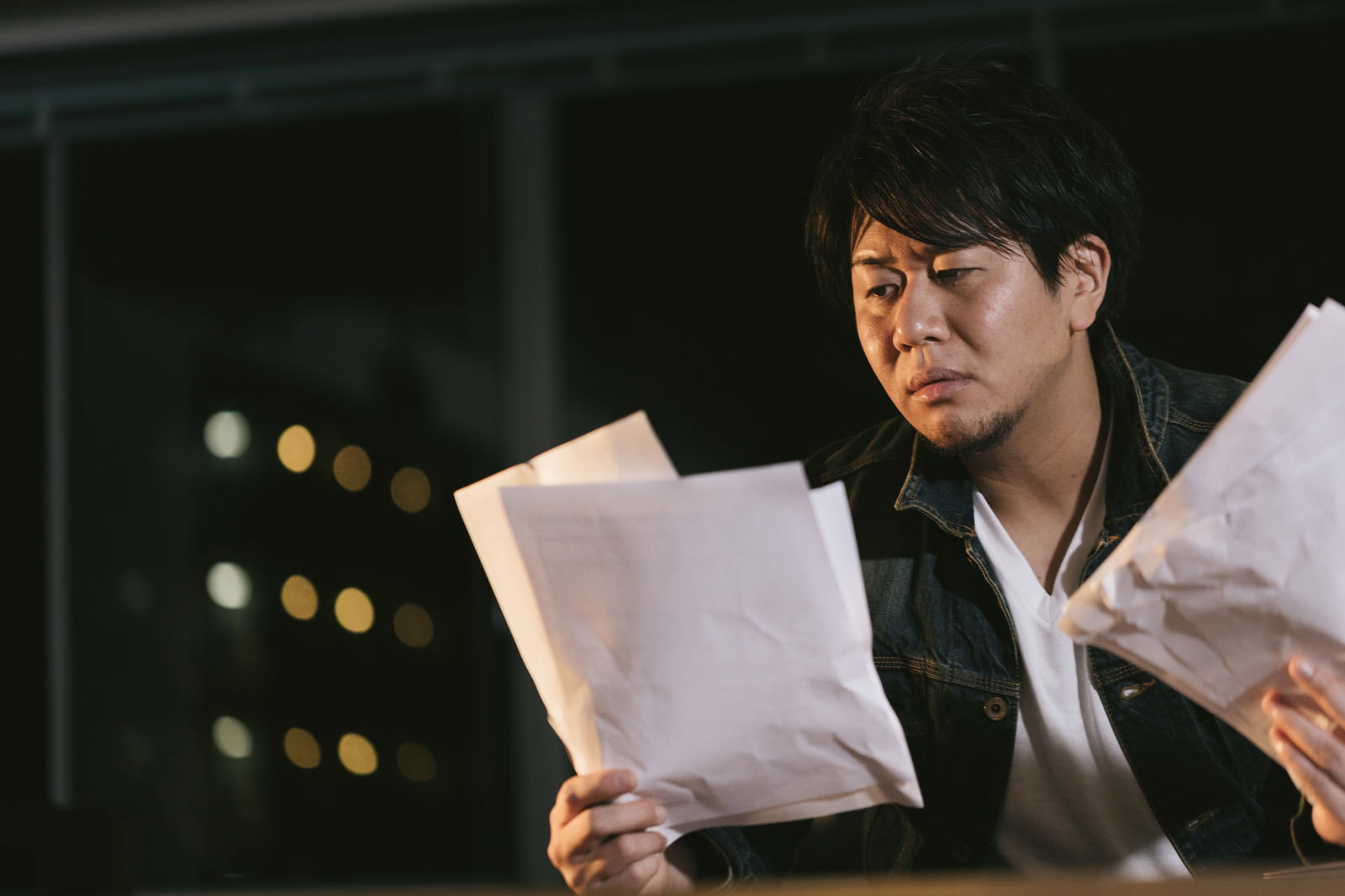 原稿を手に持ち確認する男性編集者［モデル：あまのじゃく］