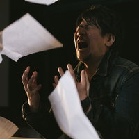 締切に間に合わず原稿を投げ捨てて叫ぶ記者の写真