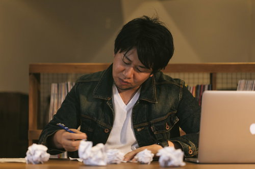 今夜も10,000文字コース、深夜のデスクで執筆を続ける男性ライター