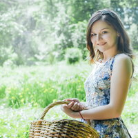 バスケットを持った笑顔のロシア人女性の屋外ポートレートの写真