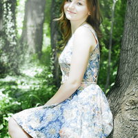 森の中で木によりかかる外国人女性の一休みの写真