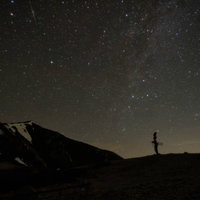 北アルプスの山並みに広がる夜空の星空の写真