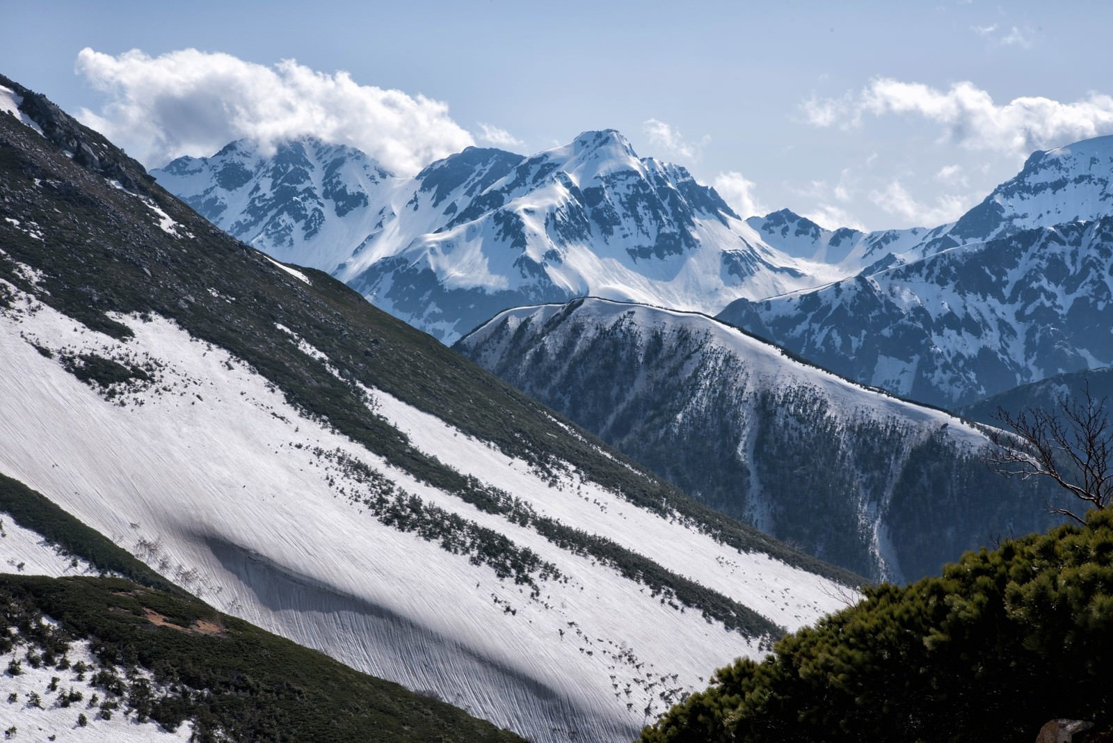 常念山脈から見た北穂高岳と立ち上る雲の山岳風景