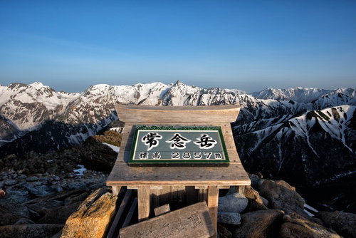 常念岳山頂の標識から望む雪化粧した山並み