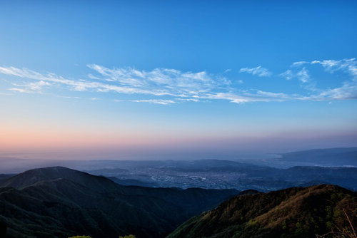 朝焼けと霞がかかる相模湾の山峰と街並みの風景