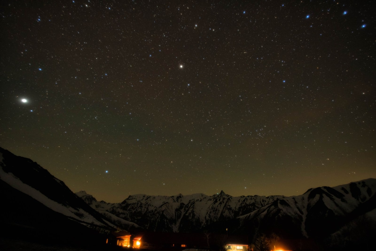 槍ヶ岳の山小屋から見える満天の星空と山々のシルエット