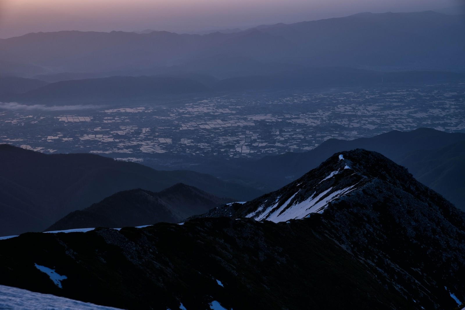朝焼けの空に映える前常念岳の山並みと安曇野の田園風景