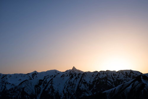 薄明の中で浮かぶ槍ヶ岳の穂先と朝焼けの山岳風景