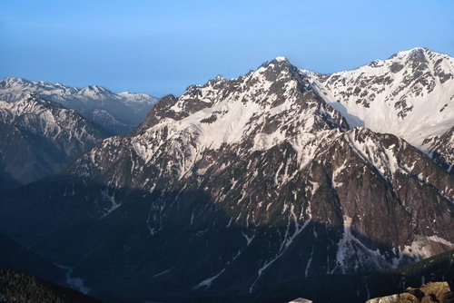 穂高岳の岩壁に残る雪と青空