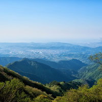鍋割山から望む秦野市の街並みと青空、山間に広がる町並みの写真
