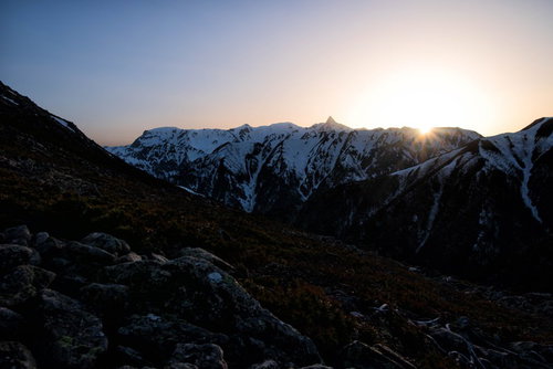 飛騨山脈の雪山に沈み行く太陽の夕焼け風景