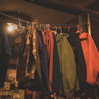 山小屋に吊るされた登山用ウェアとハンガーの写真