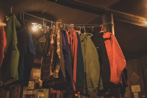 山小屋に吊るされた登山用ウェアとハンガー