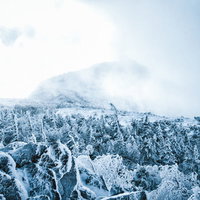 立ち込める雲に覆われた冬の天狗岳の雪山風景の写真