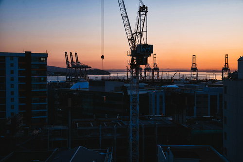 オークランドの港で朝焼けに染まるクレーンのシルエット