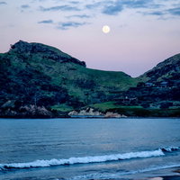 グレートバリア島の浜辺に打ち寄せる波と満月（ニュージーランド）の写真