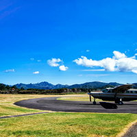 グレートバリア島の空港に停まる白い小型飛行機（ニュージーランド）の写真