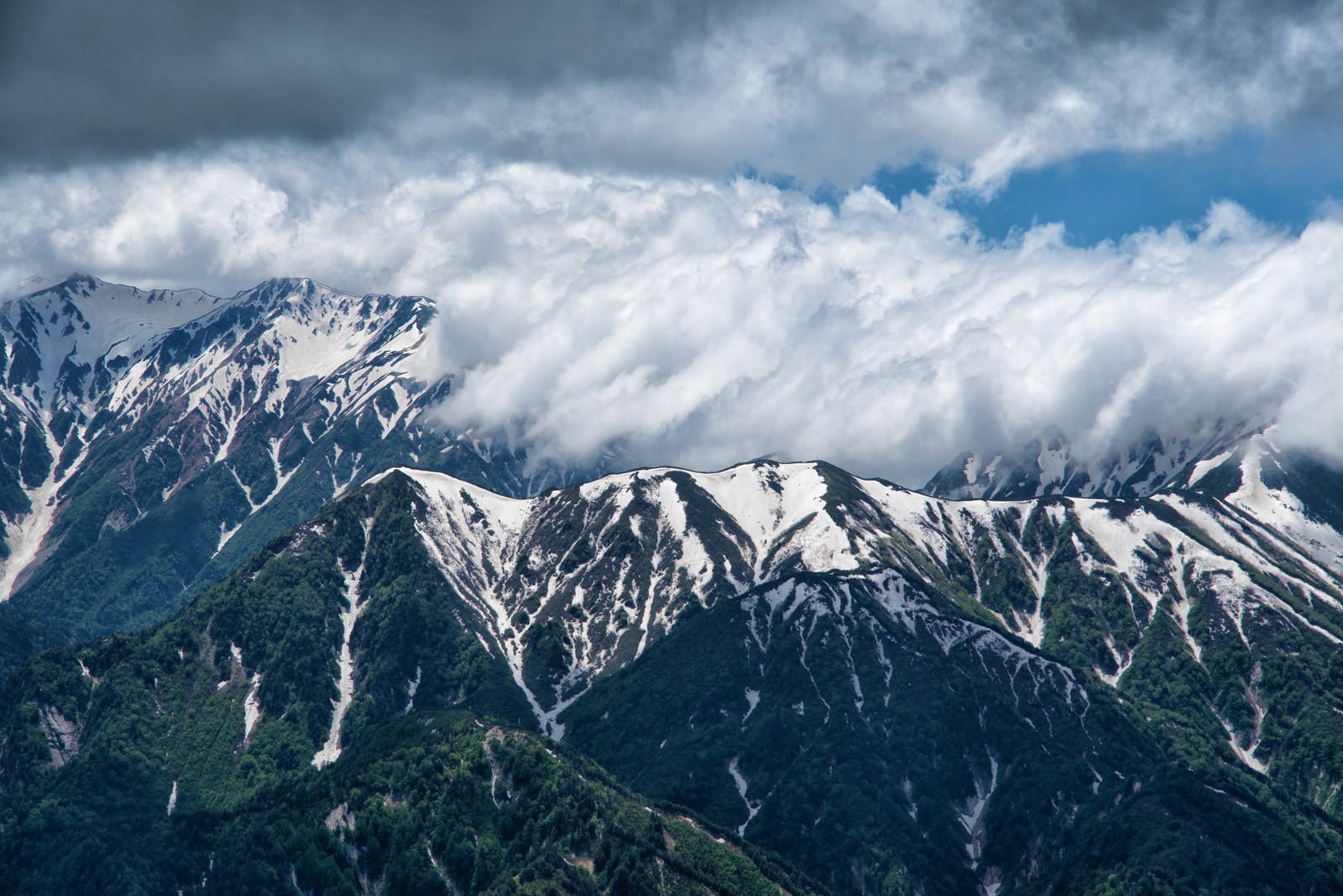 立山連峰の山々に滝雲が流れ込む雄大な山岳風景