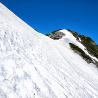 北アルプス針ノ木岳山頂直下の残雪と急斜面の写真