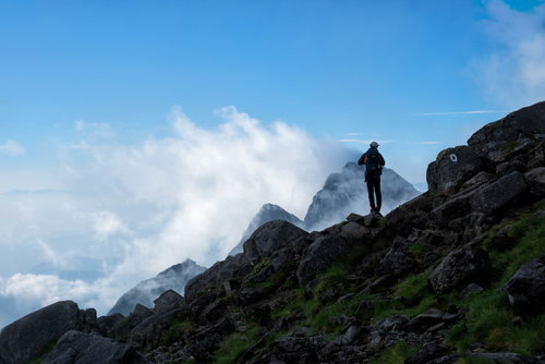 前穂高岳の岩場に立つ登山者と青空（北アルプス）