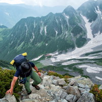 北穂高岳南陵の岩場を登る登山者の岩稜帯での登山風景の写真