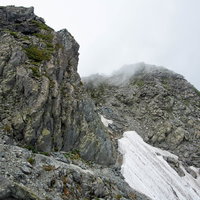 北穂高岳山頂直下の残雪が点在する険しい岩稜の写真