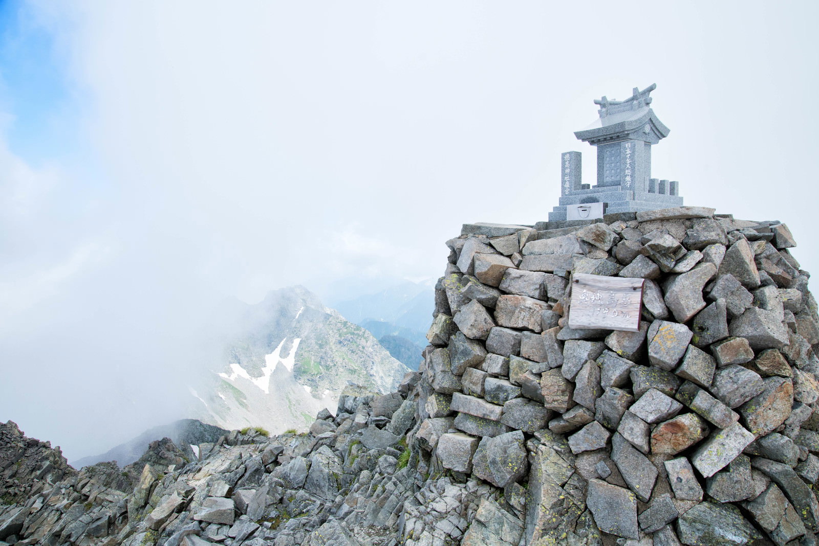 奥穂高岳山頂の穂高神社嶺宮、石積みの基壇上の祠と雲海