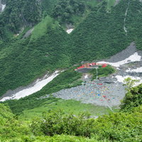 涸沢の山間に広がるパノラマコースとテントサイトの写真