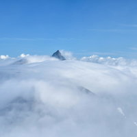 雲海から顔を出す槍ヶ岳、北アルプスの山頂が青空に突き出す絶景の写真