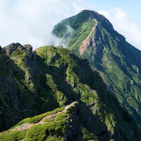 八ヶ岳・横岳の尾根にある岩場と奥に見える赤岳の写真