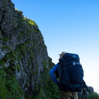 横岳の切り立った岩場を見上げる登山者（八ヶ岳）の写真