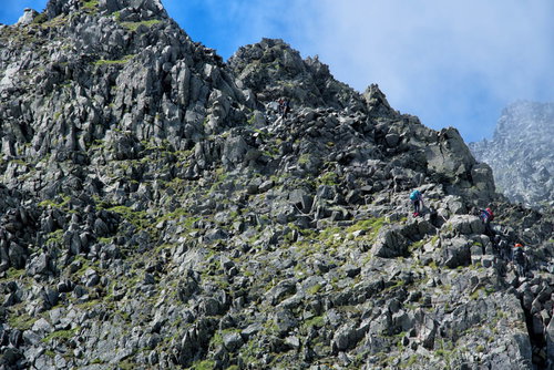 涸沢槍直下の険しい岩稜鎖場を登る登山者たち