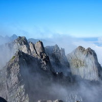 雲間から顔を出す滝谷の断崖、穂高連峰の岩稜の写真