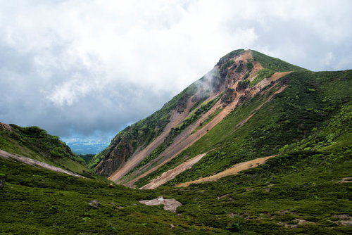 曇り空の中、登山道から見た西天狗岳（八ヶ岳連峰）
