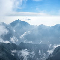 雲海の中に浮かぶ常念山脈の稜線と朝日の写真