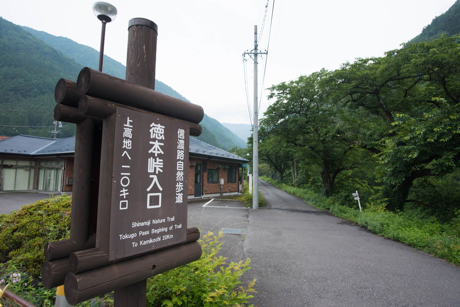山間の道路沿いに設置された徳本峠入口の木製指導標