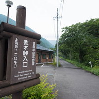 徳本峠入口に設置された木製の指導標と山道の案内板の写真